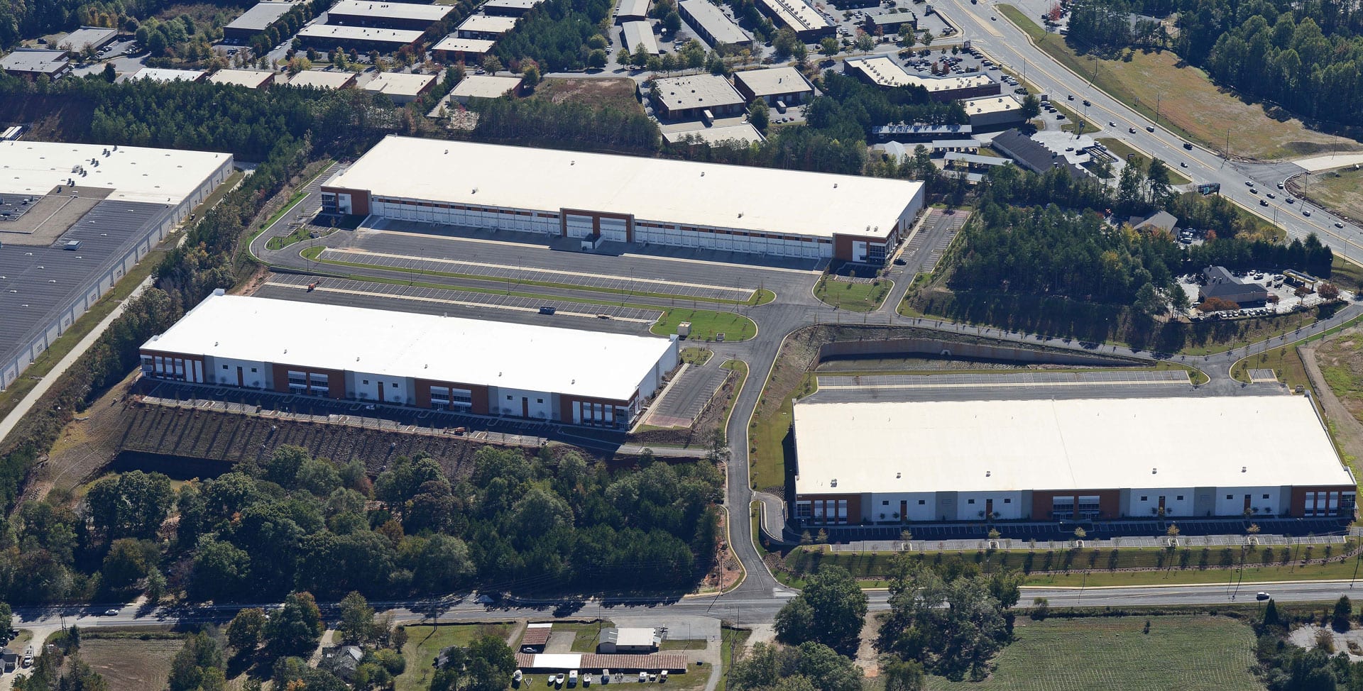 A large warehouse with many buildings in the background.