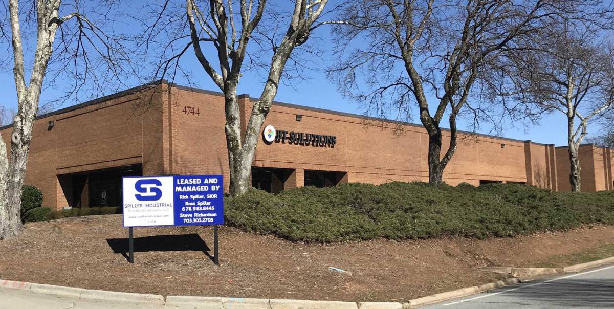 A building with trees and a sign on the side of it.