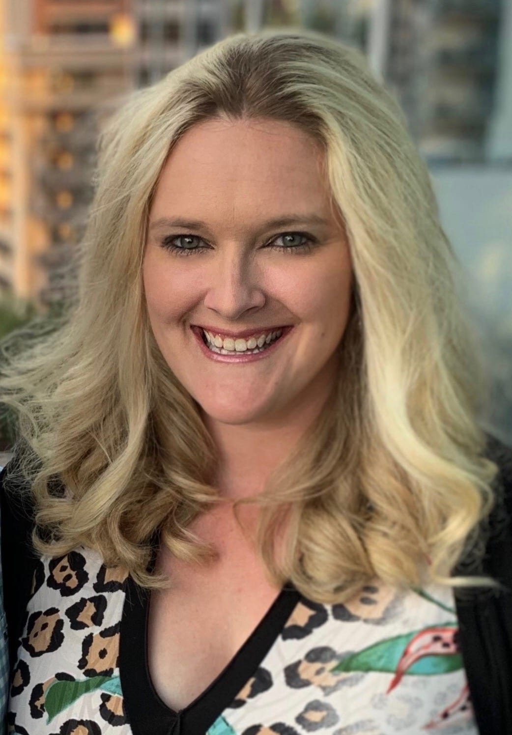 A woman with blonde hair and leopard print shirt.