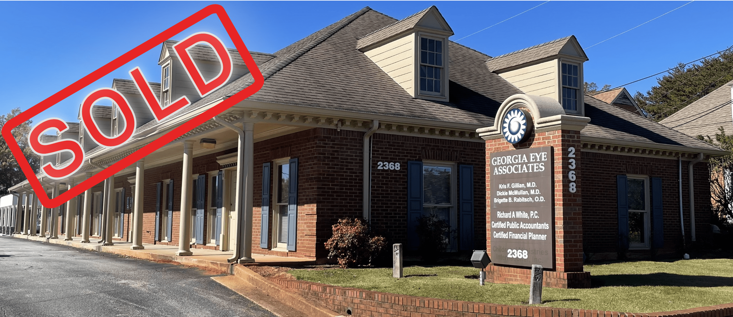 A building with a red circle around it and a street sign in front of it.