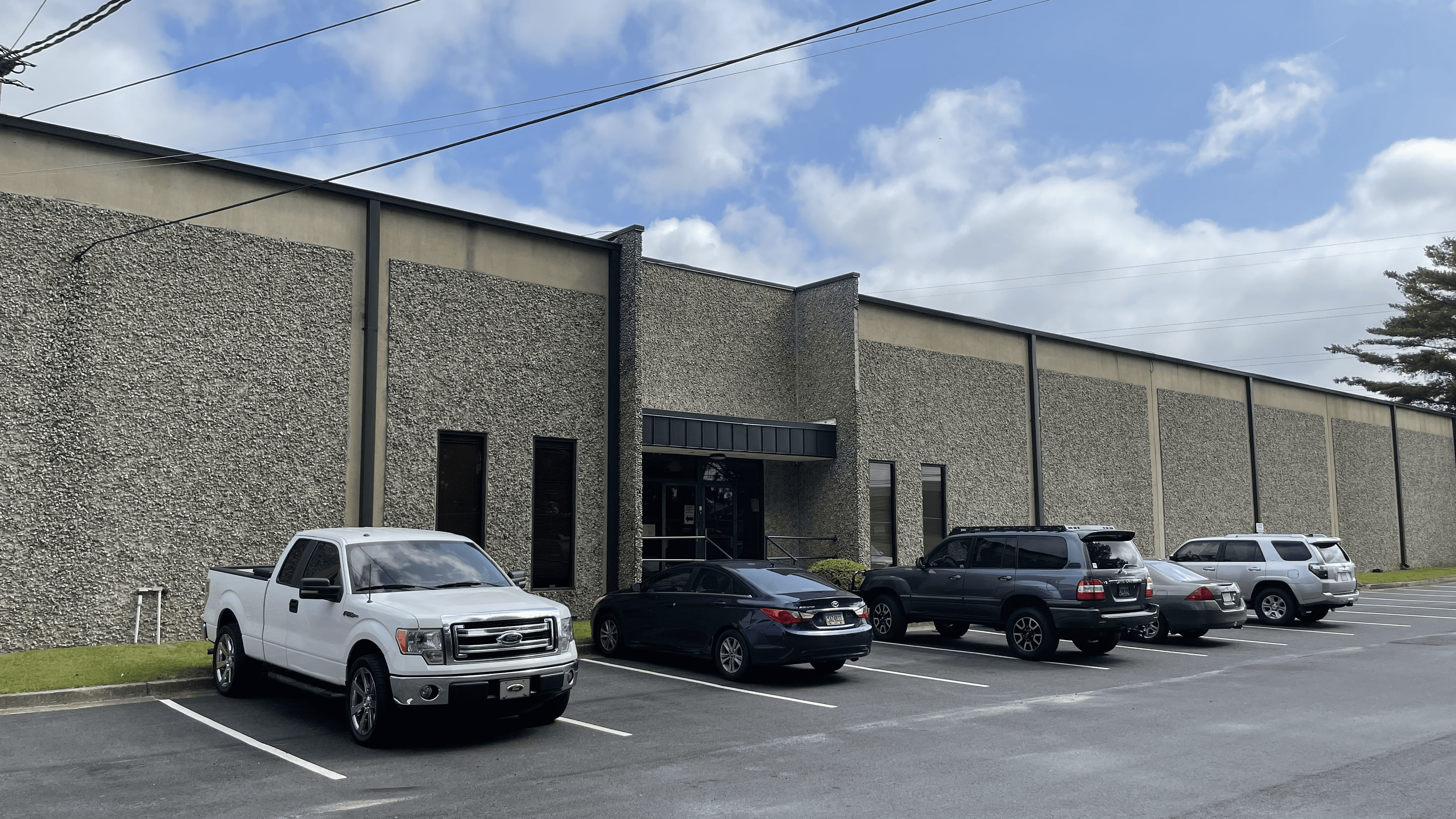 A parking lot with cars parked in front of it.