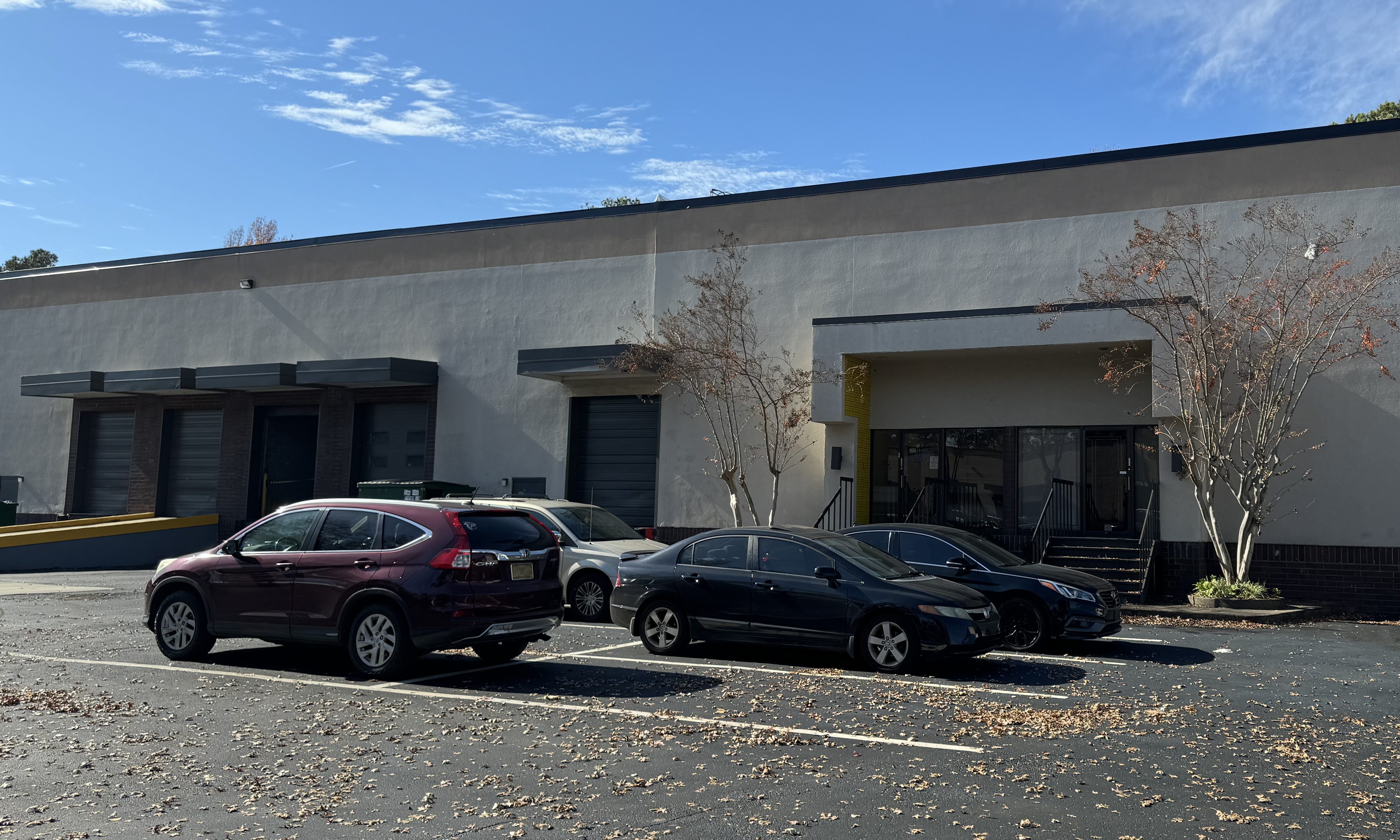 A parking lot with several cars parked in front of it.